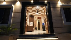Ein Hotel Eingang mit modernem Design, mit einer Holzfassade, einem gefliesten Boden und einer Sitzecke mit einem Sessel und einem kleinen Tisch.