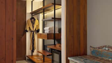 A walk-in closet with wooden shelves, a hanging robe, and a bench.