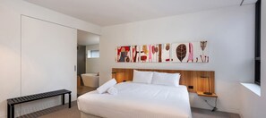 Relax in a spacious room with a large bed, bedside table, and wall-mounted artwork.