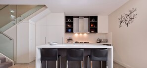 Cafetera o tetera, utensilios de cocina y mesa de comedor