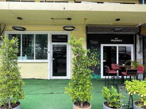 A restaurant with outdoor seating, a green artificial turf, and potted plants. - Lemon Tree Khaosan Hostel (Bangkok)
