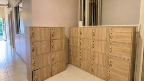 A hallway with wooden storage lockers labeled with letters and numbers. - Lemon Tree Khaosan Hostel (Bangkok)
