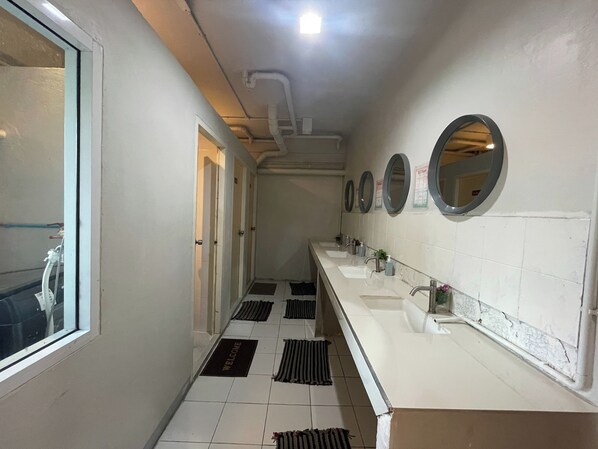 A hotel bathroom with multiple sinks, mirrors, and a tiled floor.