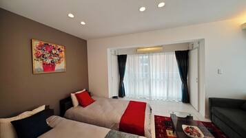 Habitació d'hotel amb dos llits, un sofà, una taula de cafè i un quadre a la paret.