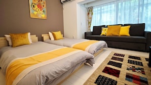 A bedroom with two beds, a sofa, a patterned rug, and a painting on the wall. - K-icon Hotels Chikusa (Nagoya)