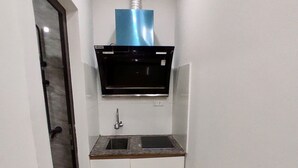 Una cocina compacta equipada con microondas, lavaplatos y campana extractora.