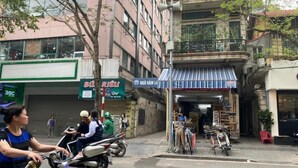 Vista de la calle con una tienda cerrada, una motocicleta y una bicicleta.