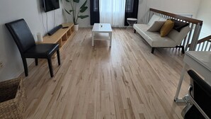 A modern living room with a flat-screen TV, a white coffee table, a sofa, and a chair. - Home away from home (Saint-Philippe)