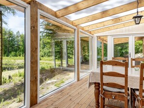A wooden deck with large windows overlooking a forested area. - Erikstorp 149 by Interhome (Olofström)