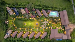 An aerial view of a resort with multiple buildings, a swimming pool, and well-lit pathways. - Sterling Orient Woods Pench (Ramtek)