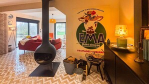 Un interior acogedor con chimenea, comedor y un amplio ventanal.