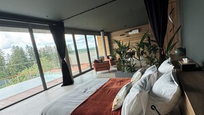 A modern bedroom with a large bed, a wooden headboard, and a view of a balcony. - Luxury private villa with heated pool, spa and sauna (Abreschviller)