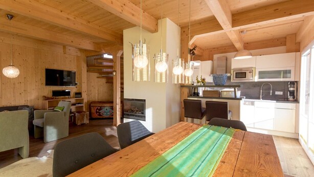 A wooden interior with a dining area, kitchen, and living space. - Amazing chalet with sauna (Sankt Georgen am Kresichberg)