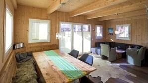 A wooden interior with a large table, seating area, and a sofa. - Amazing chalet with sauna (Sankt Georgen am Kresichberg)