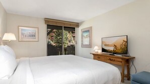 A hotel room with a large bed, a television on a wooden dresser, and two framed pictures on the wall. - Vail Village Charm - Walk Everywhere (Vail)