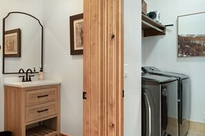 A bathroom with a wooden vanity, a mirror, a sink, and a towel rack. - EagleVail Home Near Beaver Creek - Hot Tub & Views (Avon)