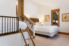 A bedroom with a bunk bed, a single bed, a wooden staircase, and a window with a view. - EagleVail Home Near Beaver Creek - Hot Tub & Views (Avon)