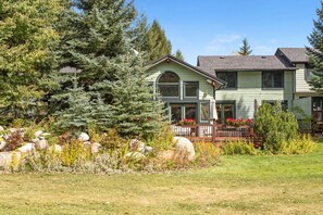 A two-story house with a porch, surrounded by a garden with rocks and plants. - EagleVail Home Near Beaver Creek - Hot Tub & Views (Avon)