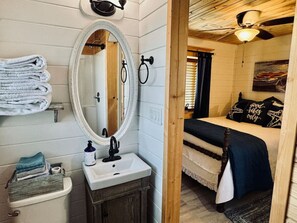 A bathroom with a sink, mirror, and towels.