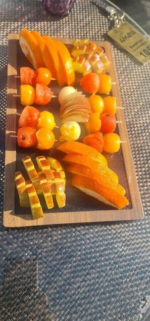 Fresh fruit skewers arranged on a woven surface.