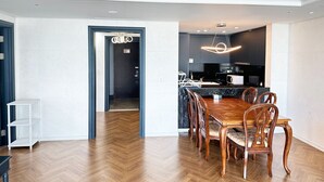 A modern kitchen with dark cabinets, a central island, and a built-in microwave. - CENTUMCITY HOTEL (Busan)