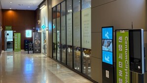 A hotel corridor with glass doors, digital screens, and signage in a foreign language. - CENTUMCITY HOTEL (Busan)