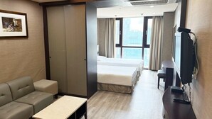 A hotel room with a bed, a sofa, a TV, and a desk. - CENTUMCITY HOTEL (Busan)