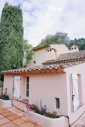 Ein Gebäude im traditionellen mediterranen Stil mit Terrakotta-Dachziegeln, weißen Wänden und kleinen Fenstern.