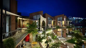 Experience the serene ambiance of our outdoor courtyard, featuring seating areas, a small bridge, and lush greenery.