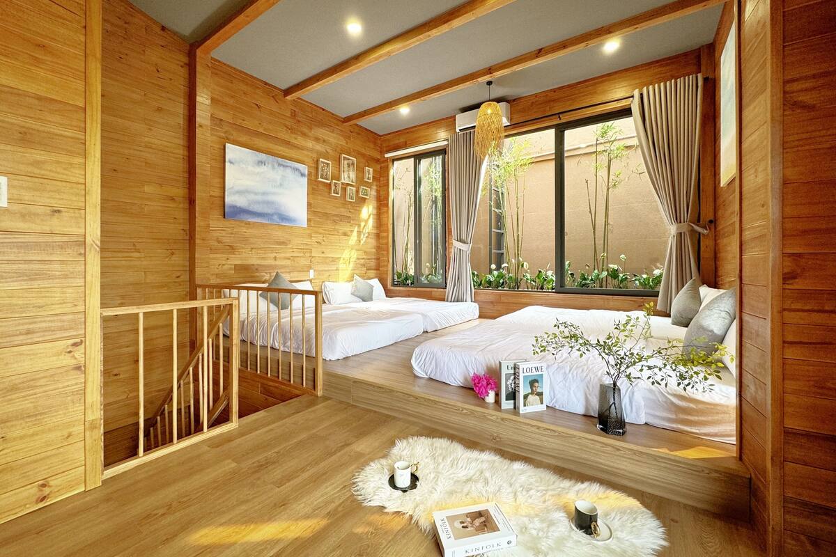 A wooden cabin with two bedrooms, a balcony, and a large window with curtains.