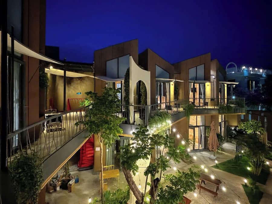 Um edifício moderno com vários níveis, áreas de estar ao ar livre e um pátio bem iluminado.