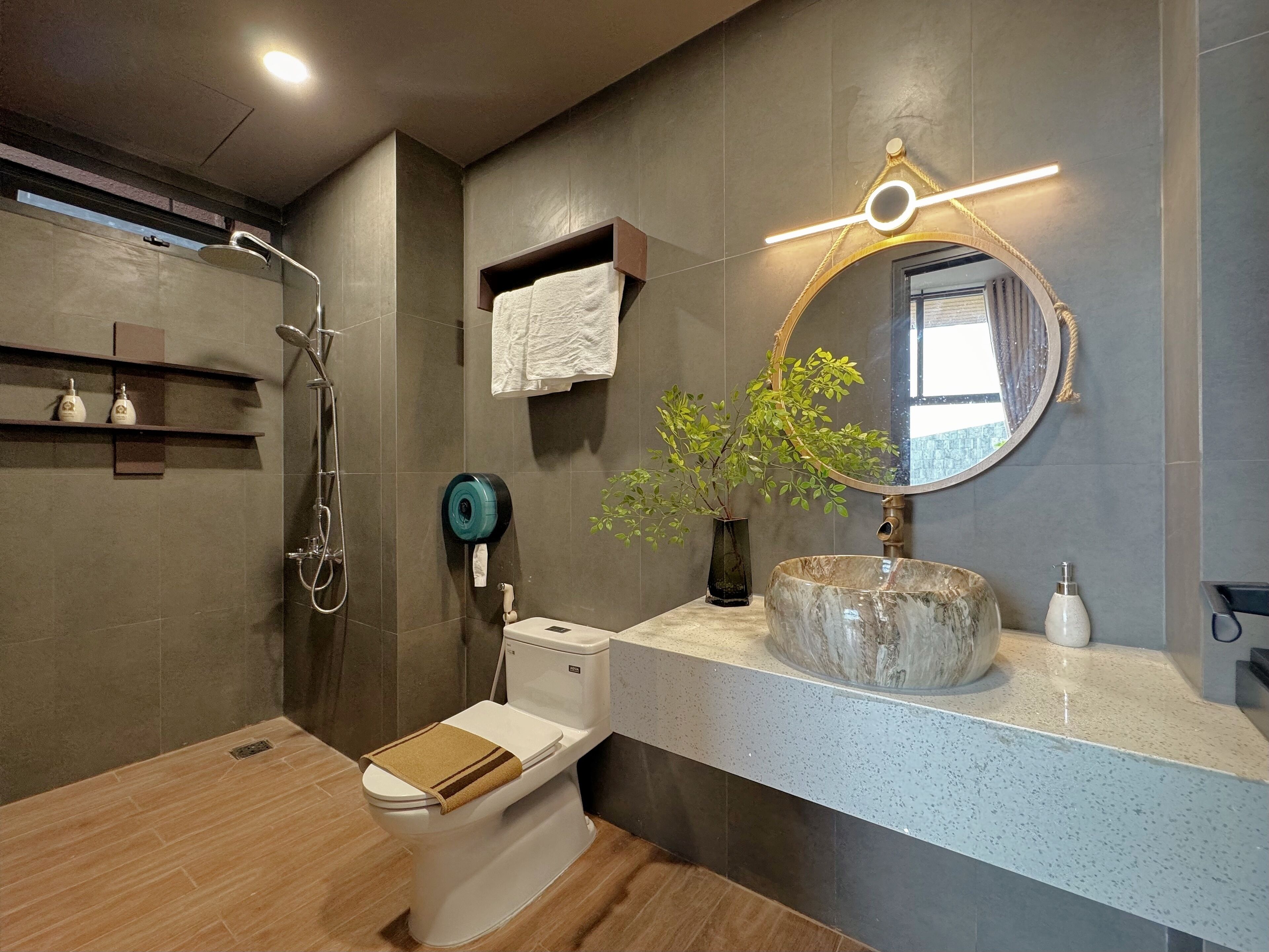 A modern bathroom with a shower, toilet, and sink.