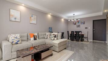 Apartamento ejecutivo, 1 cama de matrimonio grande, vistas a la ciudad | Zona de estar | Smart TV de 65 pulgadas con canales por cable, una chimenea