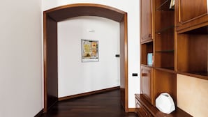 Ein Flur mit einer Holzbücherreolen, einer weißen Wand und einem Poster.