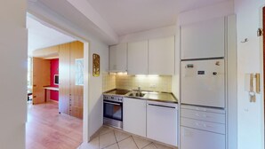 A modern kitchen with white cabinets, a stainless steel sink, and a built-in oven.