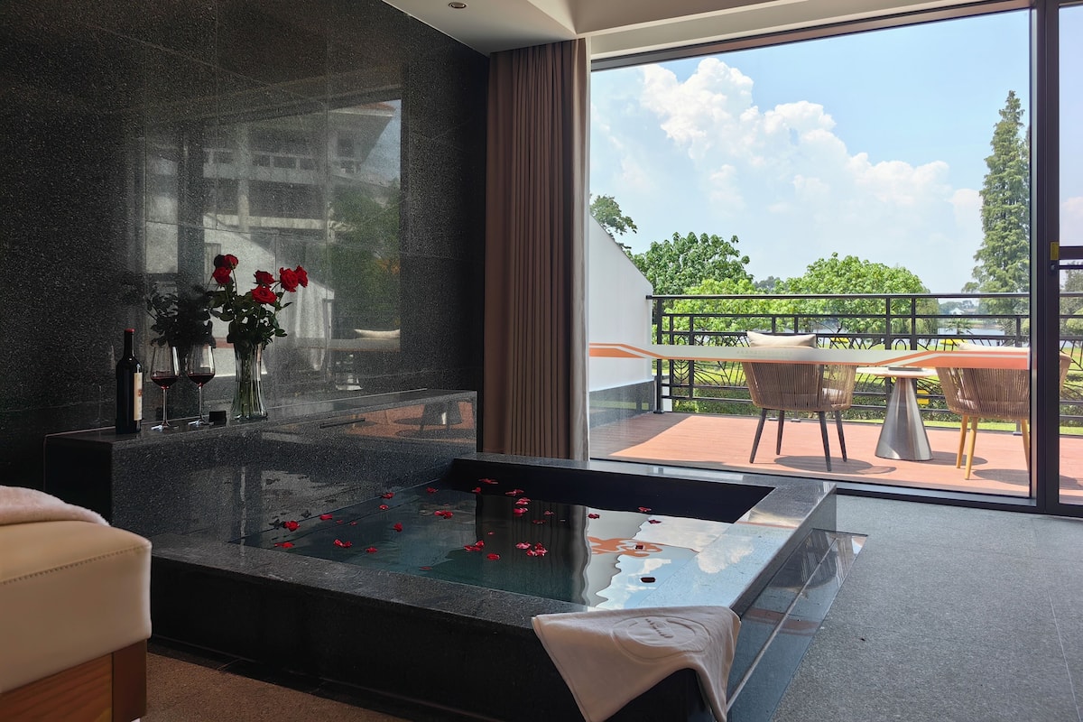 Ein modernes Badezimmer mit einer einbruchsicheren Dusche, einer Marmorarbeitsplatte und Blick auf einen Balkon mit Gartenmöbeln.