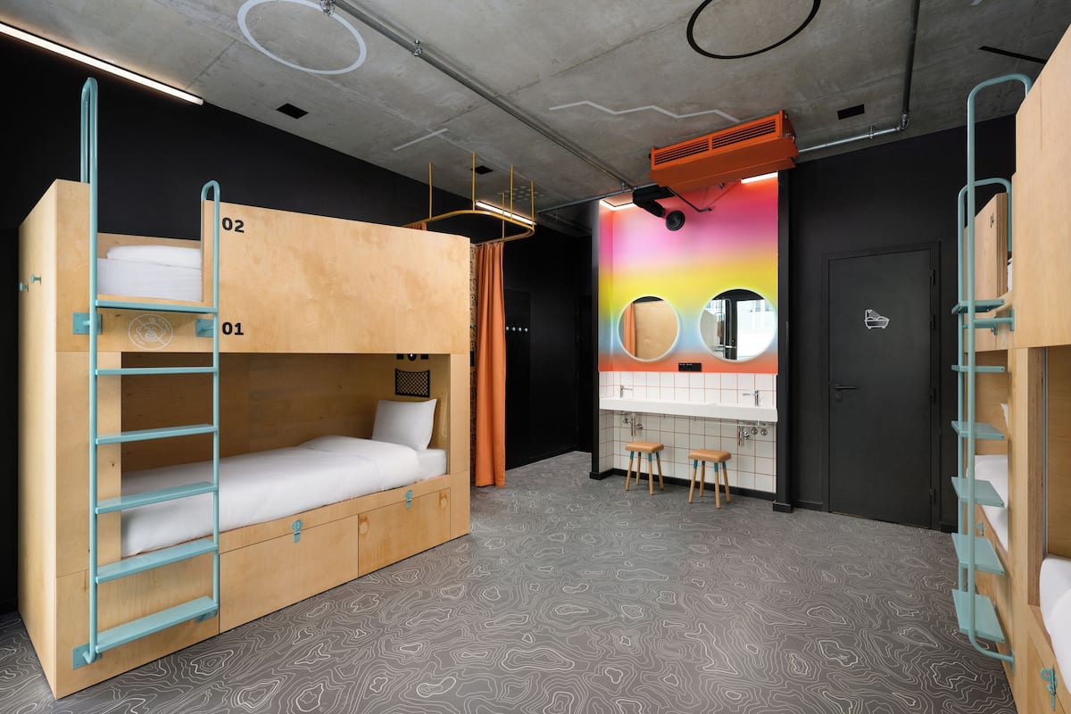 A bunk bed room with a bathroom and a mirror.