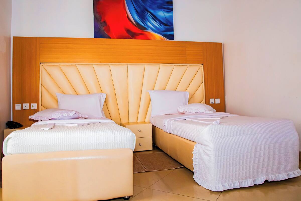 A double bed with a wooden headboard, two bedside tables, and a nightstand.
