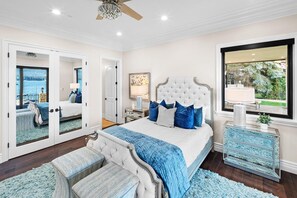 A bedroom with a large bed, a mirror, a dresser, and a window with a view. - Waterfront Dreams: Luxurious Lakefront! Incredible Views! 5 Masters! A/C! Extravagant Outdoor Living! Hot Tub! Pool Table and more! (Fawnskin)