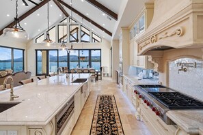 Una cocina amplia con una isla grande, electrodomésticos modernos y vistas al exterior.