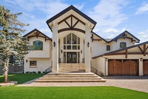 Una casa moderna con entrada central, ventanas amplias y un césped bien cuidado.