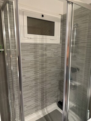 Studio | Badkamer | Een douche, een haardroger, handdoeken