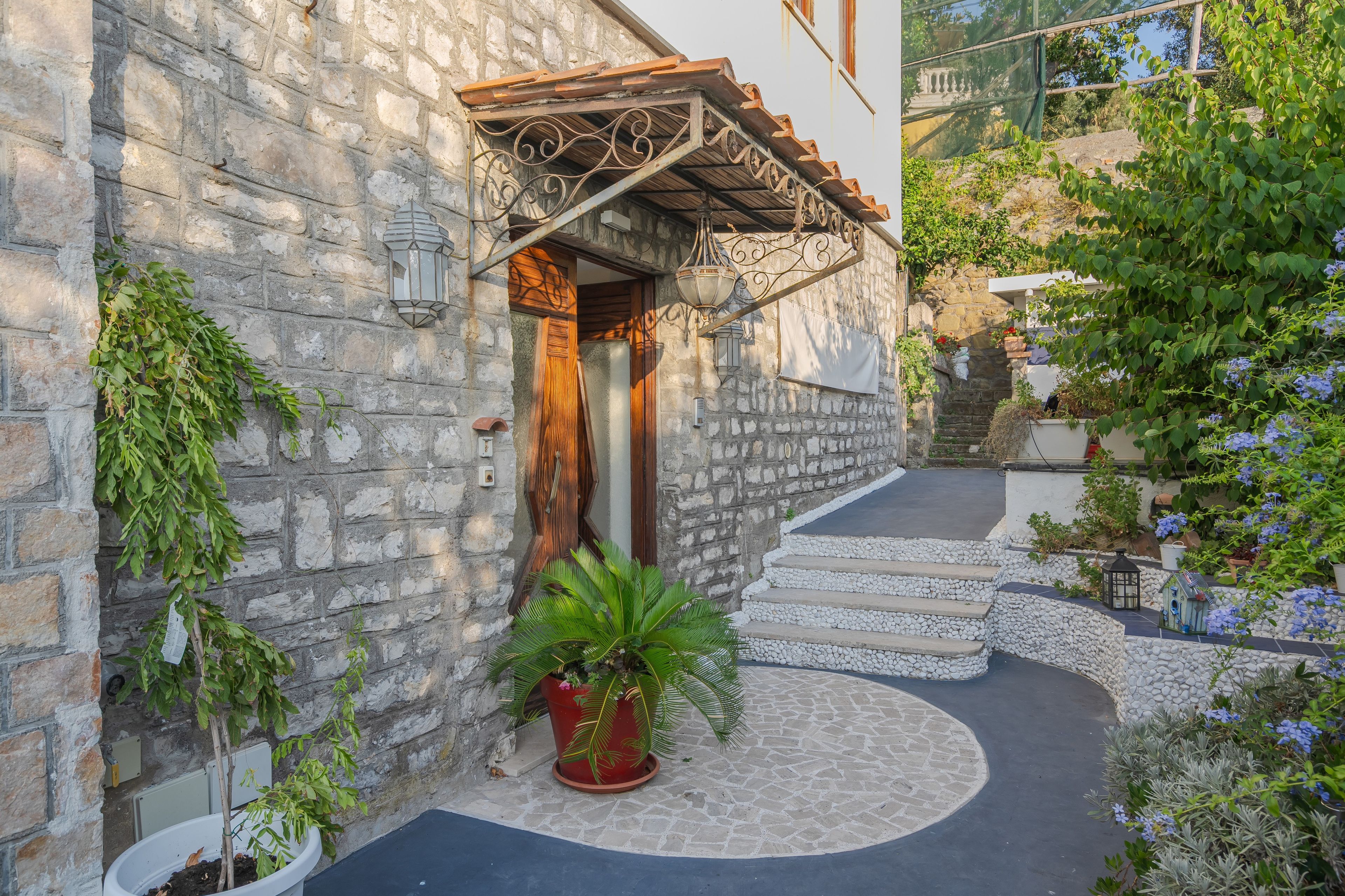 A stone building with a wooden door and steps leading to a stone staircase.