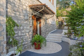 Un edificio de piedra con una puerta de madera y escalones que conducen a una escalera de piedra.