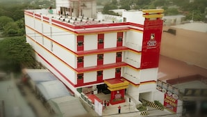 Ein mehrstöckiges Hotel mit roter und weißer Fassade, mehreren Balkonen und einer Dachkonstruktion.