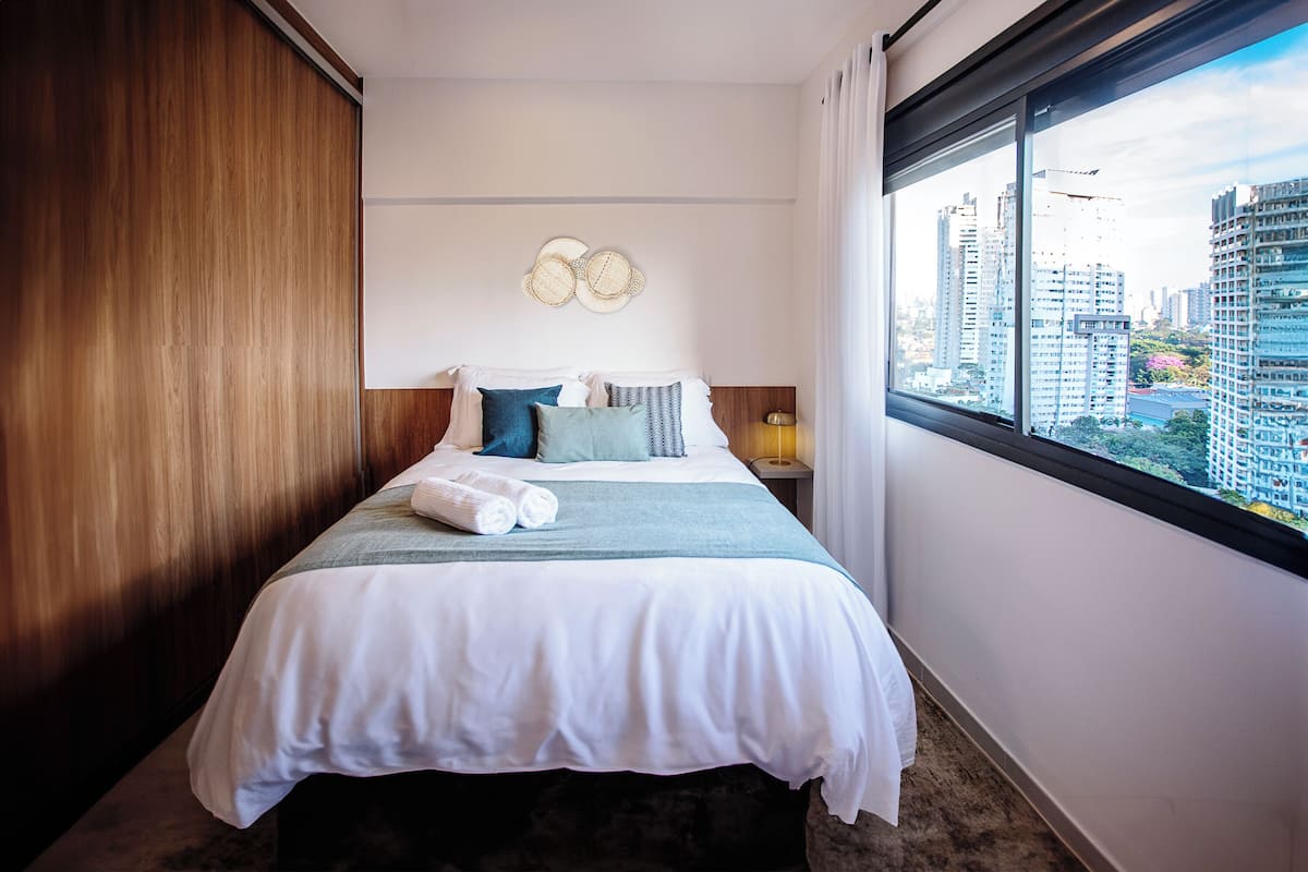 Ein Hotelzimmer mit Bett, Blick auf die Stadt und einer Holzwand.