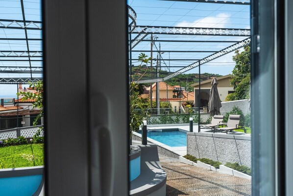 Un espace piscine offrant une vue sur un quartier résidentiel, avec des maisons et un ciel dégagé.