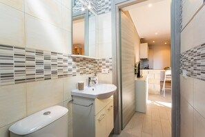 A modern bathroom with a toilet, sink, and shower area.