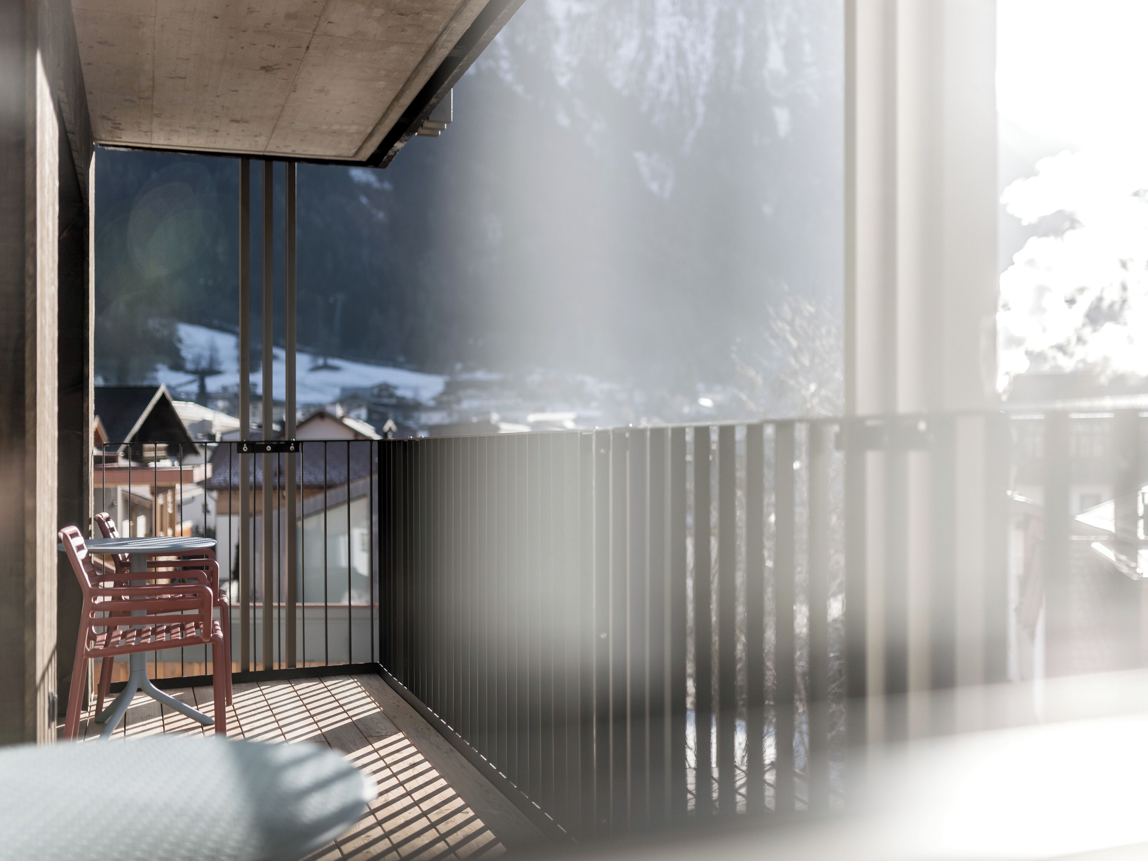 A modern interior with a balcony overlooking a snowy landscape.