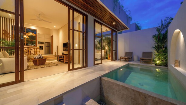 A modern house with a swimming pool, large sliding glass doors, and a cozy interior with furniture. - Villa Inka (Canggu)